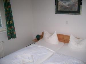 a bed with white sheets and pillows on it at Parkresidenz Sanssouci in Zinnowitz