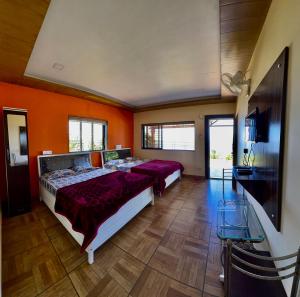 a bedroom with two beds and a flat screen tv at Heavens Edge Resort in Mahabaleshwar