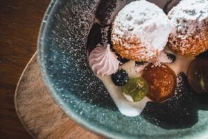 a plate of donuts with powdered sugar on it at Tornácos Hotel - Hegykő in Hegykő