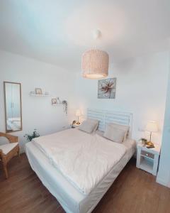 a white bedroom with a bed and a mirror at Casa Rosalia Puerto del Carmen in Puerto del Carmen