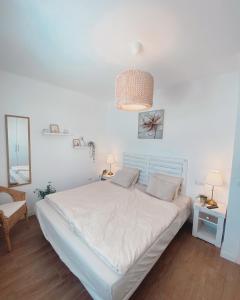 ein weißes Schlafzimmer mit einem Bett und einem Spiegel in der Unterkunft Casa Rosalia Puerto del Carmen in Puerto del Carmen