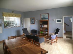 een woonkamer met een houten tafel en stoelen bij villa Canthar in Saint-Pair-sur-Mer