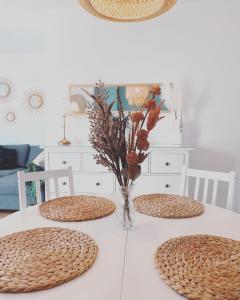 卡門港的住宿－Casa Rosalia Puerto del Carmen，一张带两把椅子的白色桌子和花瓶