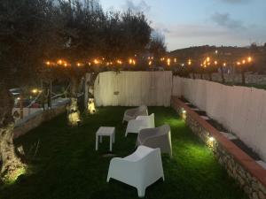 a backyard with white chairs and lights on the grass at Acquamarina in Gaeta
