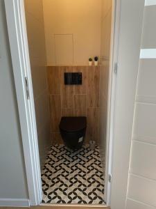 Łazienka z czarną toaletą i czarno-białą podłogą w obiekcie Apartament z widokiem na Gorzów w mieście Gorzów Wielkopolski