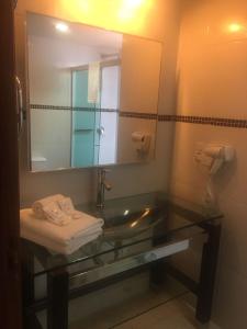 a bathroom with a sink and a mirror at Emirates Hotel & Suites in Santana do Livramento