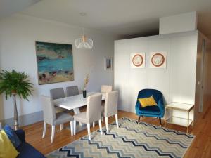 a dining room with a white table and chairs at Lusitania Garden Apartment - Jardim Privado in Porto