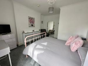 a bedroom with a white bed and a television at Chic & Cosy Studio Apartment in Southampton +1 photo