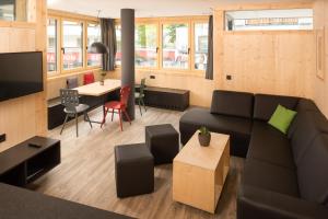 - un salon avec un canapé et une table dans l'établissement fire & ice LIVING, à Ischgl