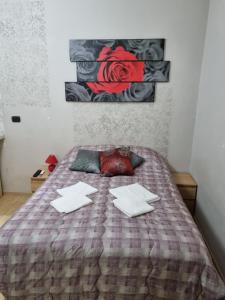 - un lit avec deux oreillers et un tableau mural dans l'établissement RED ROSE, à Rome