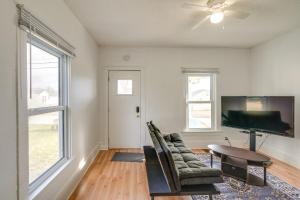 a living room with a tv and a couch and a table at Cedar Rapids Vacation Home Near Downtown District! in Cedar Rapids