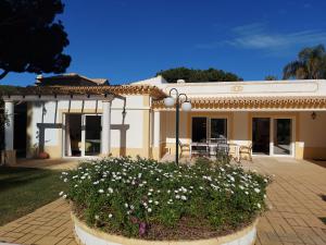 una casa con un jardín con flores delante en The Pinewood Villa, en Vilamoura