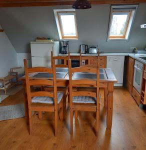 cocina con mesa de madera y sillas en Ferienwohnung am Papensee en Hohen Sprenz