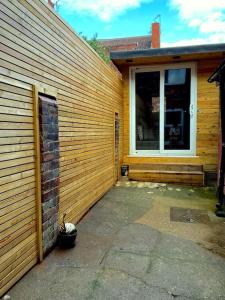a house with a wooden wall next to a door at Newly refurbished city house with Hot Tub in Lincoln
