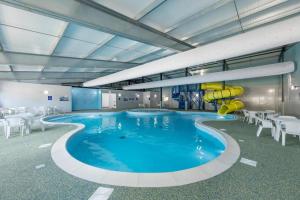 a large swimming pool with a slide in a building at Birchington Vale entire holiday home in Westgate on Sea