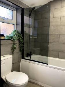 a bathroom with a toilet and a bath tub at Newly refurbished city house with Hot Tub in Lincoln