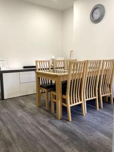 a dining room table with chairs and a clock on the wall at Newly refurbished city house with Hot Tub in Lincoln