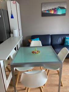 ein Tisch und Stühle in einem Wohnzimmer mit einer Couch in der Unterkunft Cosy, zuidgerichte studio in De Panne met WiFi in De Panne + 13 Fotos
