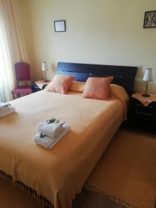 una camera da letto con un grande letto con due asciugamani di Alojamento Local Casa Veras a Vila Real