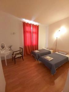 a room with two beds and a red curtain at Apartman Brina in Kanfanar