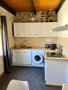 a kitchen with a washing machine and a sink at Studio de charme au coeur de Valréas in Valréas