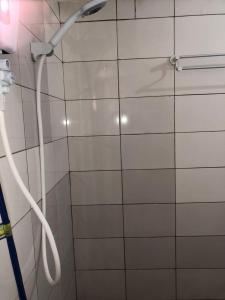 a shower in a bathroom with a white tile wall at Appart F2 plein centre in Klétigan