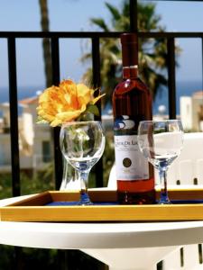 Una botella de vino y dos copas en una mesa. en Hilltop Gardens Hotel Apartments, en Pafos
