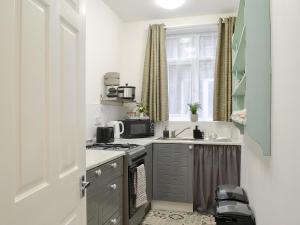 a small kitchen with a stove and a sink at Brincliffe Landing - Uk42799 in Bridlington