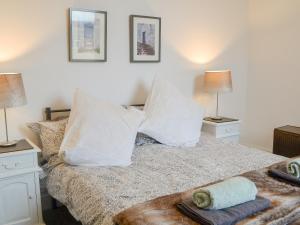 a bedroom with a bed with pillows and two lamps at Brincliffe Landing - Uk42799 in Bridlington