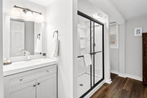 een witte badkamer met een wastafel en een douche bij Lambert's Cove Inn & Resort in West Tisbury