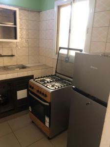 a kitchen with a stove and a refrigerator at Appart F2 plein centre in Klétigan