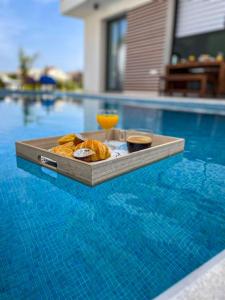 una bandeja de comida en una mesa de la piscina en By the Beach Villa Natalya en Protaras