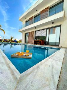 une maison avec une piscine à côté d'un bâtiment dans l'établissement By the Beach Villa Natalya, à Protaras