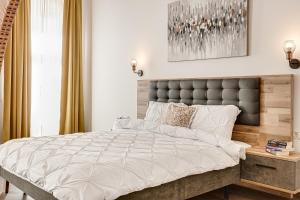 a bedroom with a large bed with a wooden headboard at ARI Central Grand Apartment in Arad
