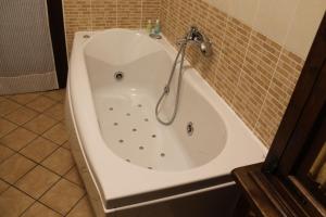 een wit bad met een kraan in de badkamer bij Casa Riva in Terni