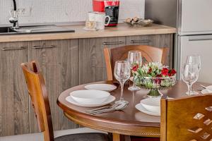 a table with plates and wine glasses on it in a kitchen at ARI Central Grand Apartments - Luxurious Stay in Arad