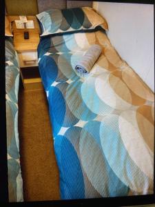 ein Bett mit einer Daunendecke mit einer Rolle darauf in der Unterkunft Birchington Vale entire holiday home in Westgate-on-Sea