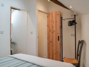 um quarto com uma cama e uma porta de madeira em Ugly Duckling Cottage em Broughton in Furness