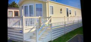 a mobile home with a white fence and stairs at Birchington Vale entire holiday home in Westgate-on-Sea