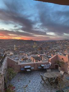 uma vista para a cidade a partir de uma varanda com mesas e cadeiras em Riad Inaya Fez em Fez