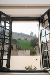 an open window with a view of a castle at La Maison de Jean by Maison Bacou in Carcassonne