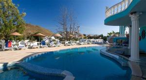 a swimming pool with chairs and umbrellas at a resort at ASPAT HOTEL BODRUM - Beach&Restaurant in Bodrum City