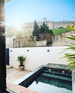 une piscine en face d'un mur avec un château dans l'établissement La Maison de Jean by Maison Bacou, à Carcassonne