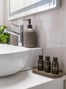 lavabo en el baño con 2 botellas de aceites esenciales en una bandeja en Cozy studio in Dafnes near to Heraklion, en Dhafnés