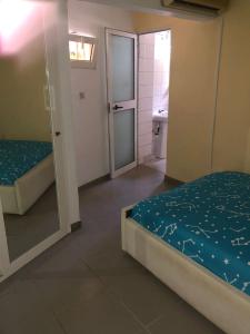 a room with two beds and a bathroom with a mirror at Appart F2 plein centre in Klétigan