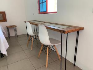 a table with two white chairs sitting at it at El Chirris Tzanjay in San Juan La Laguna +21 photos