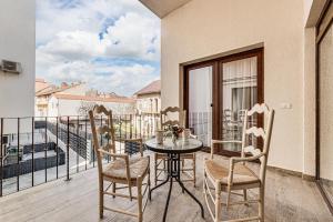 a table and chairs on a balcony with a view at ARI Central Grand Apartments - Luxurious Stay in Arad