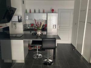 a kitchen with a black counter with a vase of flowers at Magnifique studio tout équipé classé 2 étoiles in Saint-Leu