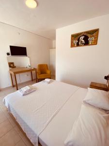 ASPAT HOTEL BODRUM - Beach&Restaurant في بودروم: غرفة نوم مع سرير أبيض كبير ومكتب