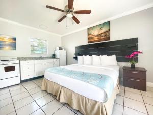 1 dormitorio con 1 cama grande y ventilador de techo en Ocean Villas, en Hollywood
